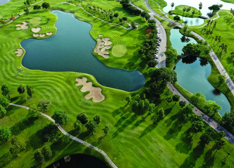 Illustrative photograph, not the development: an aerial view of golf fairways, bunkers and a lake at Sentosa Golf Club