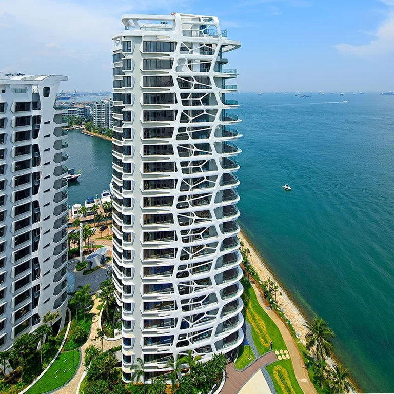 Cape Royale, photograph: an aerial view of a tower with its coral-like facade above the beach and gardens, the sea stretching away to the right